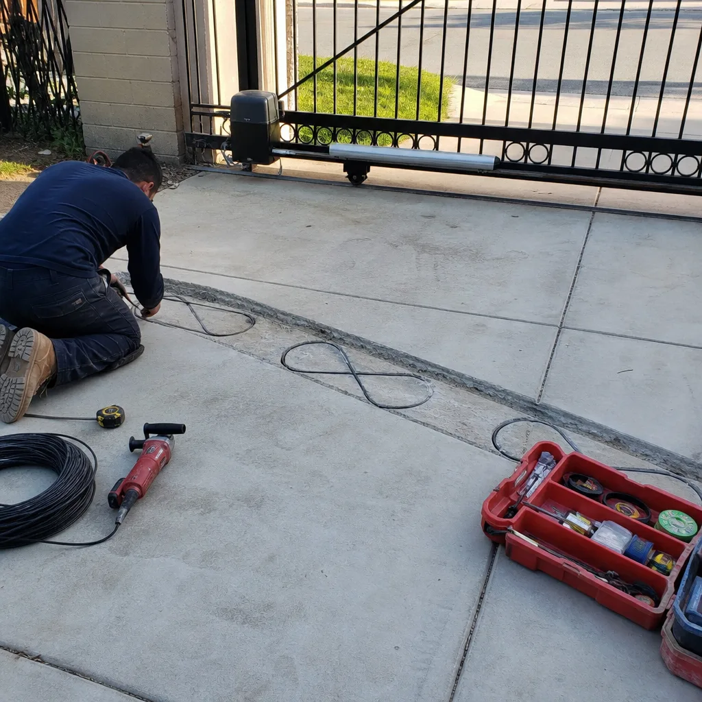 Technician installing inductive loop sensors for an automatic gate access system in Burbank, CA